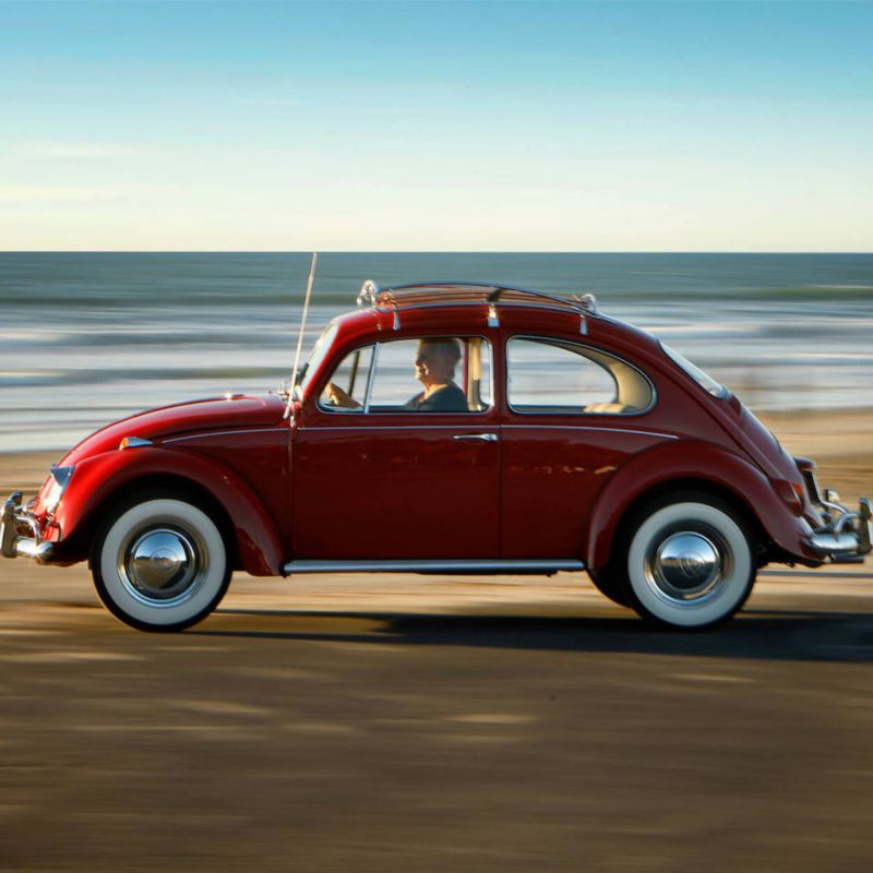 Kathleen Brooks drives her restored 1967 Volkswagen Beetle by the ocean.
