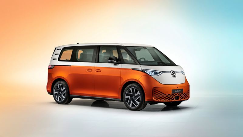 A profile shot of an ID. Buzz in Energetic Orange parked and spotlighted against a dark background.