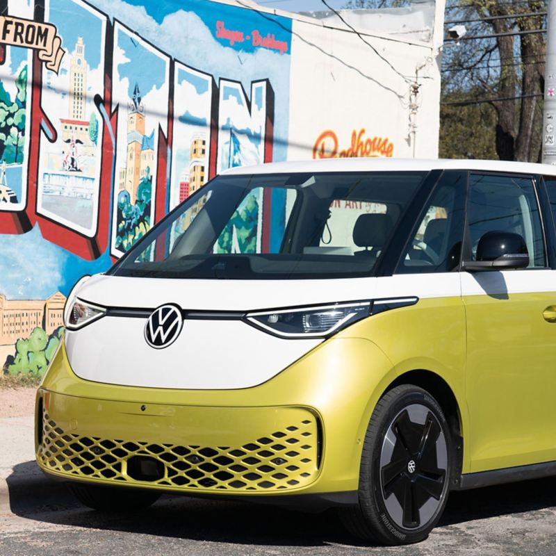 ID.4 Buzz in Candy White and Lime Yellow is parked in front of a mural that read Greetings from Austin.