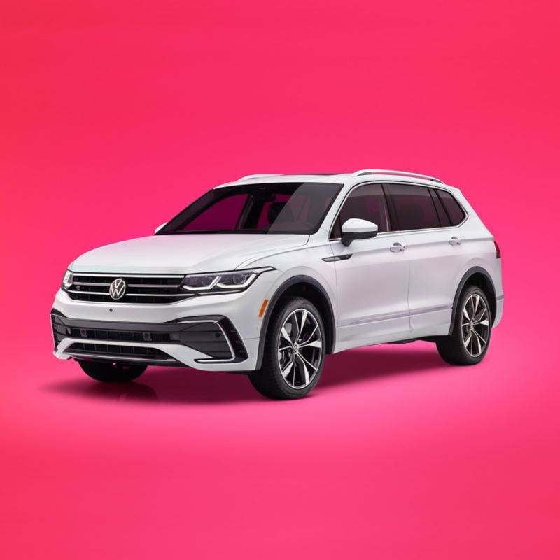 A three-quarter, front view of a Tiguan shown in Oryx White Pearl on a colorful pink gradient background