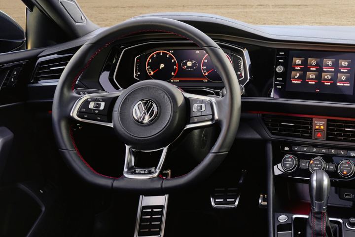 Toma del tablero digital del Golf GTI de VW, la pantalla táctil de medios y el famoso volante con la parte inferior plana con detalle apanalado.