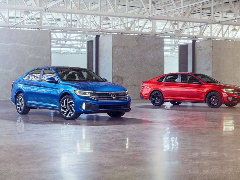 Product shot of the 2022 Volkswagen Jetta and 2022 Volkswagen 2022 Jetta GLI side by side in a studio.