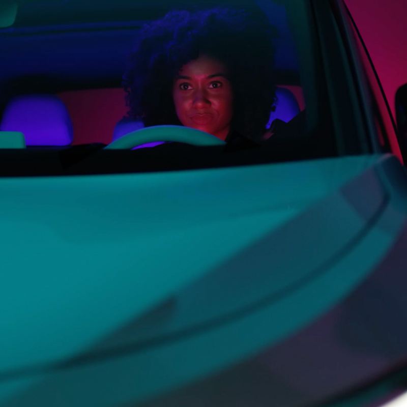 Imagen de una mujer conduciendo un auto en la carretera.