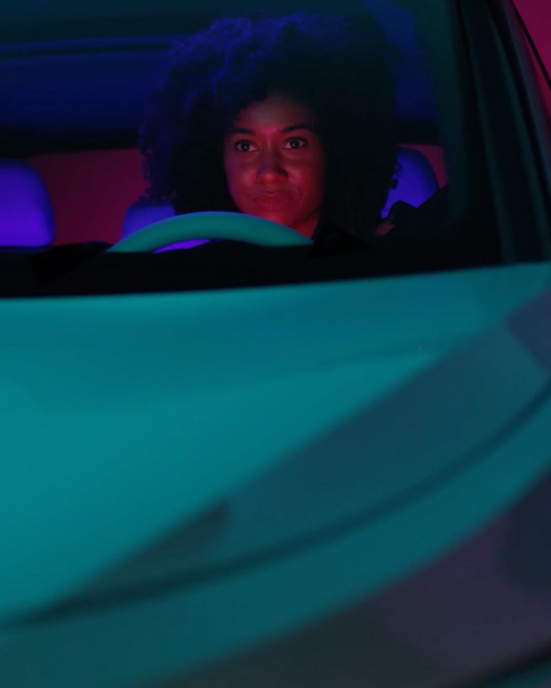 Imagen de una mujer conduciendo un auto en la carretera.