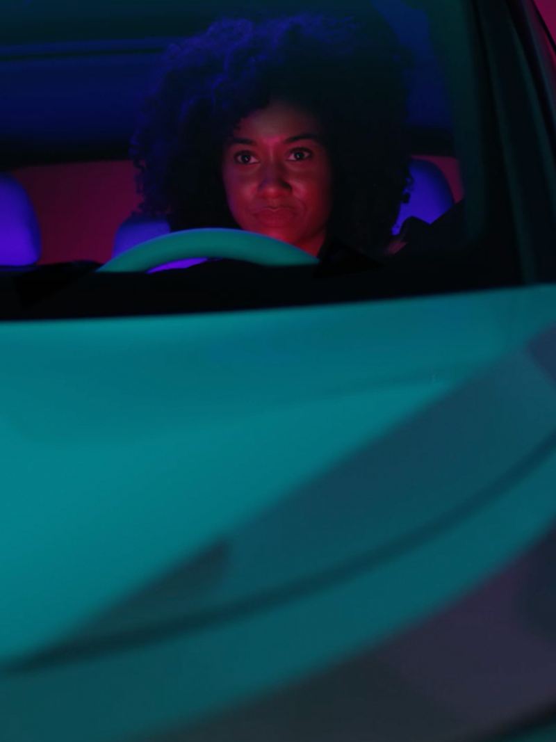Image of a woman driving a car down the road.