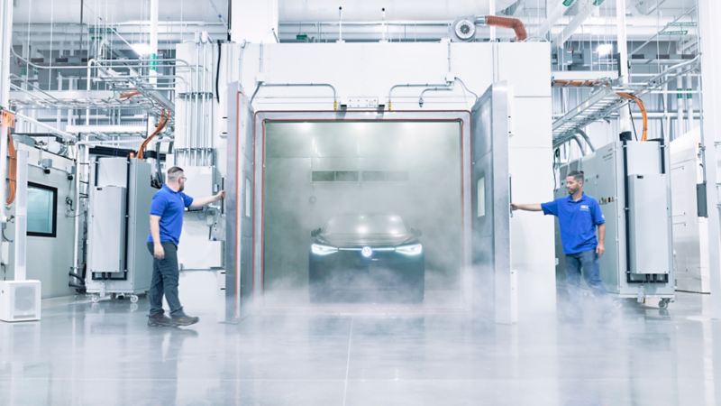 Charles Abend and Jeff Drumm open doors to testing chamber with Volkswagen ID.4 EV inside.
