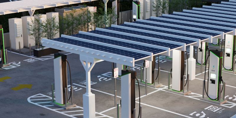 Photo illustration: aerial view of an Electrify America charging station, showing solar canopies.