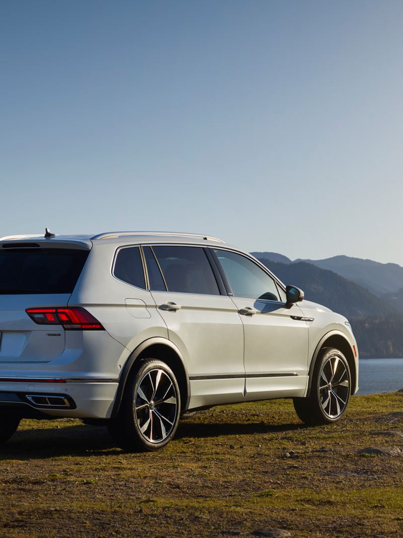 The refreshed 2022 Volkswagen Tiguan shown in rear three-quarter view by a lake.