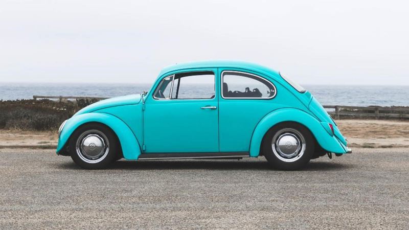 Vintage Volkswagen Beetle parked in front of the ocean