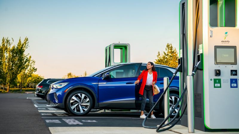A woman with a 2022 ID.4 Pro S at an Electrify America charging station. 