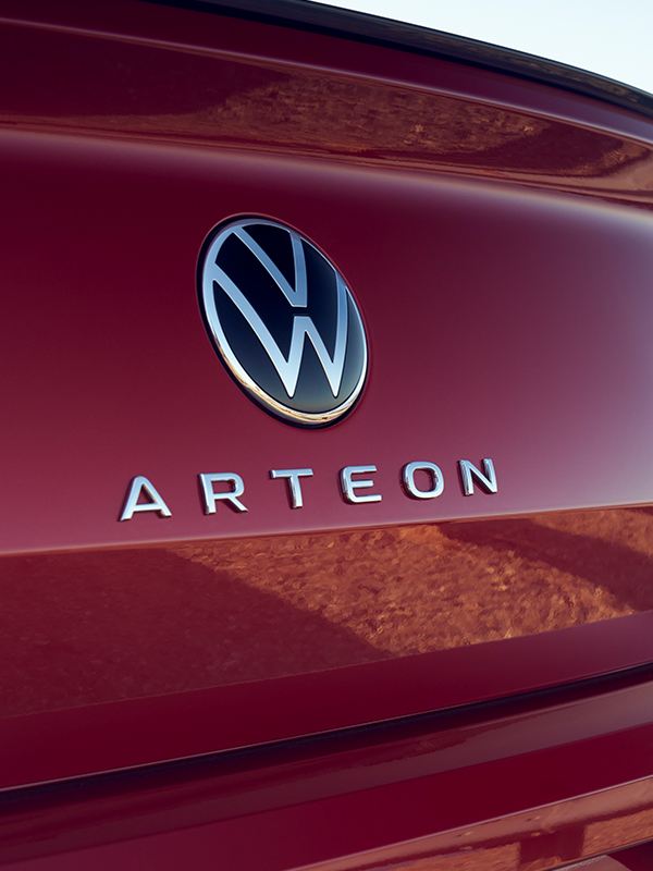 Vista trasera de un Arteon en Kings Red Metallic con el emblema trasero con el nombre de Arteon centrado debajo del emblema de VW.