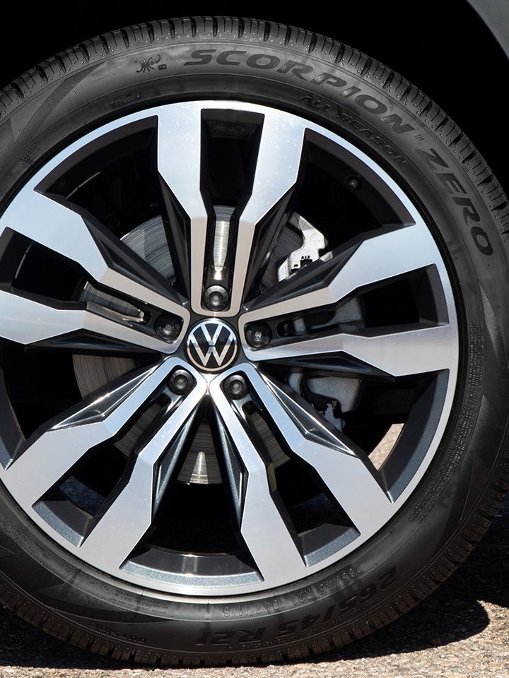 Close-up shot of the front passenger side of an Atlas in Pyrite Silver Metallic, highlighting the available 21” two-toned alloy wheel.
