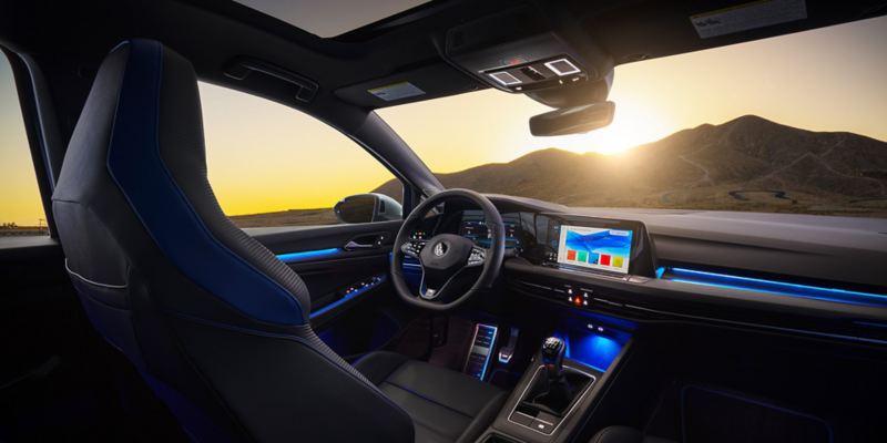 Golf R interior showing front seat, steering wheel and dash with blue ambient lighting on