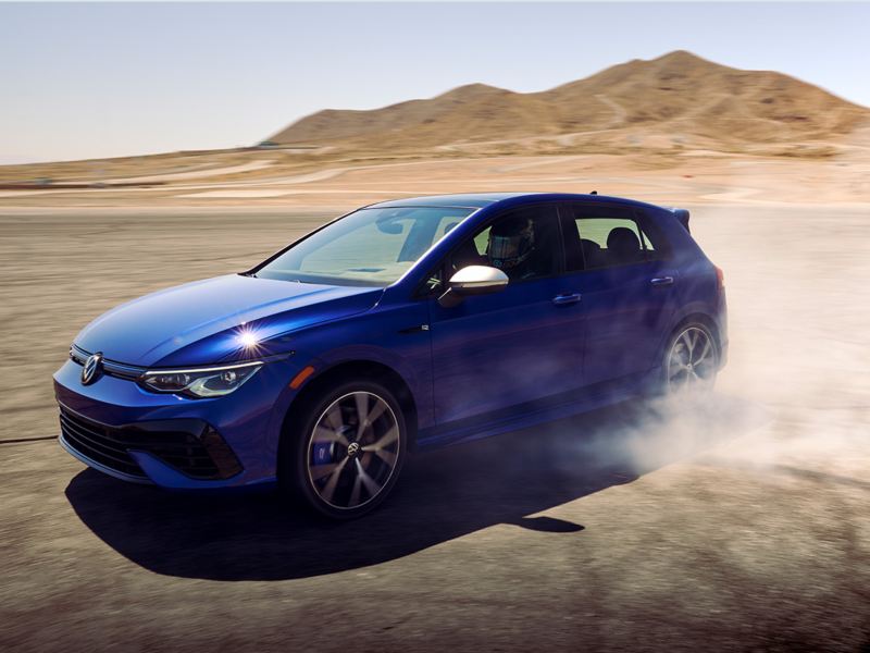 Golf R shown in Lapiz Blue Metallic, cornering with tires smoking.
