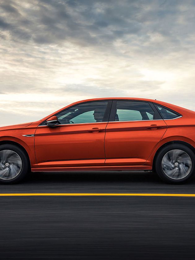 A driver’s side profile of the Jetta shown in Habanero Orange Metallic in motion.