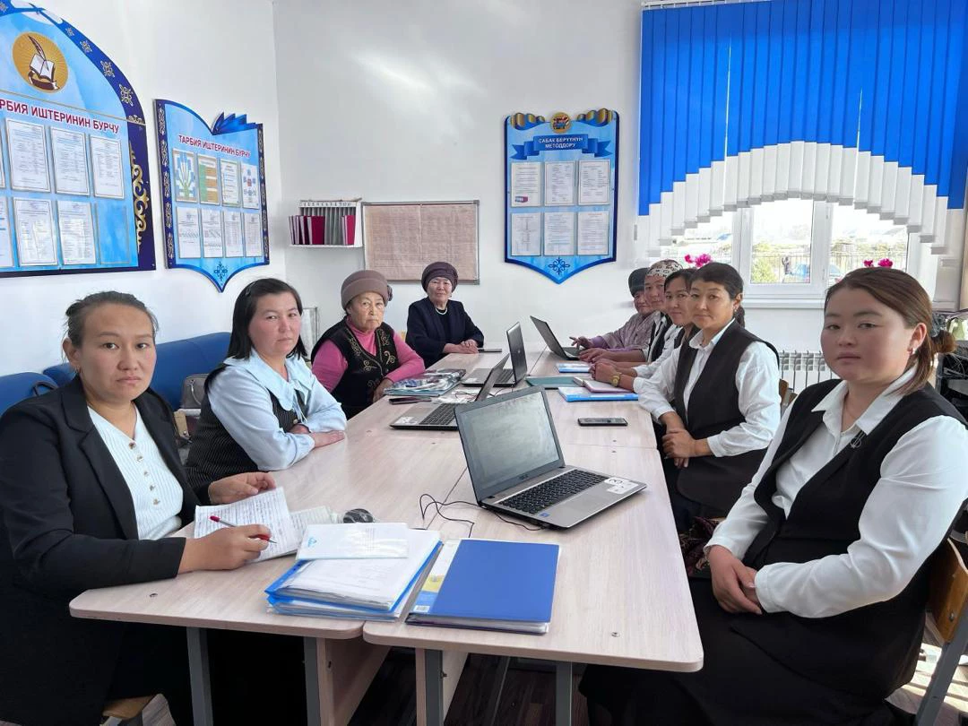 Female students sit around a table with laptops thanks to a project to connect remote communities in the Kyrgyz Republic