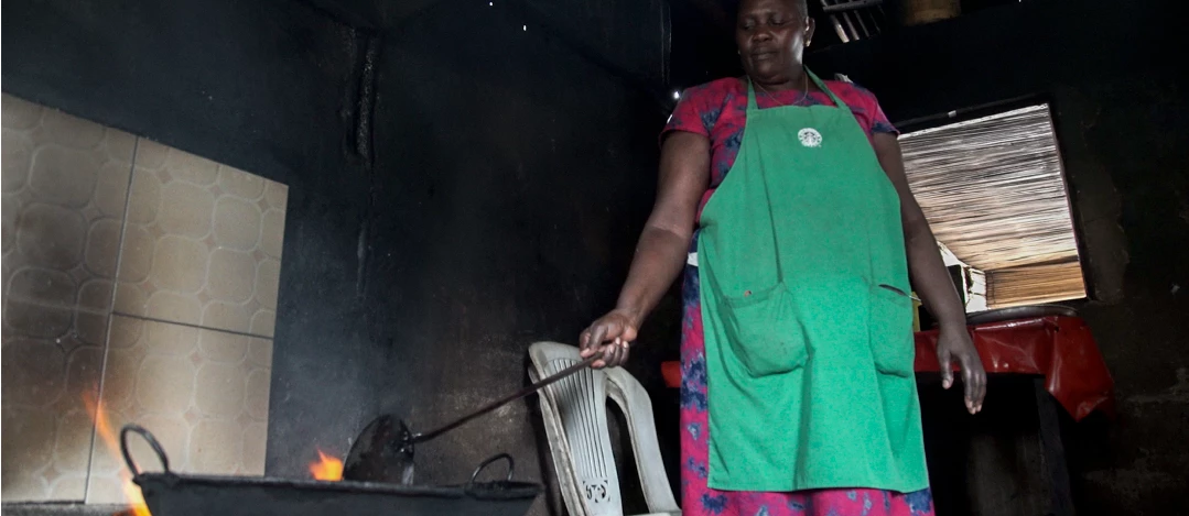 Florence Adino prepares fish at her restaurant on the shores of Lake Victoria in Kisumu, Kenya. She recently installed a rocket stove in her kitchen, which is more economical and cleaner than her old stove, allowing Adino to expand her business. Photo: Peter Kapuscinski / World Bank