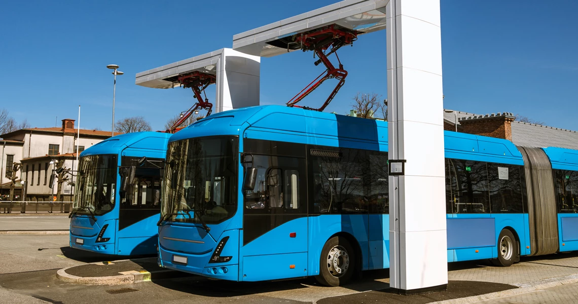 Electric buses charging in a parking lot.