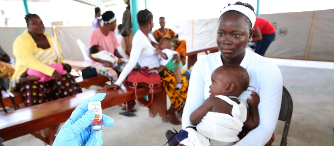  nurse (hands in far left) prepares to vaccinate children at Redemption Hospital in Monrovia