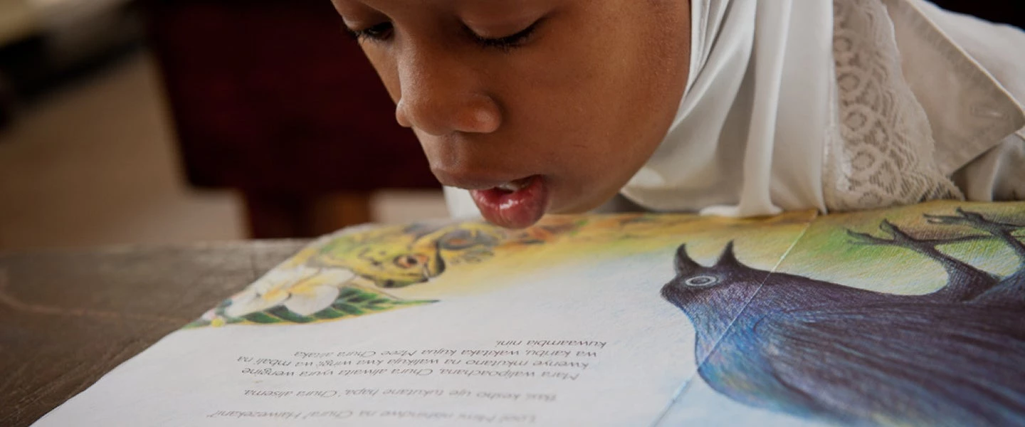 a young student reads in Tanzania.