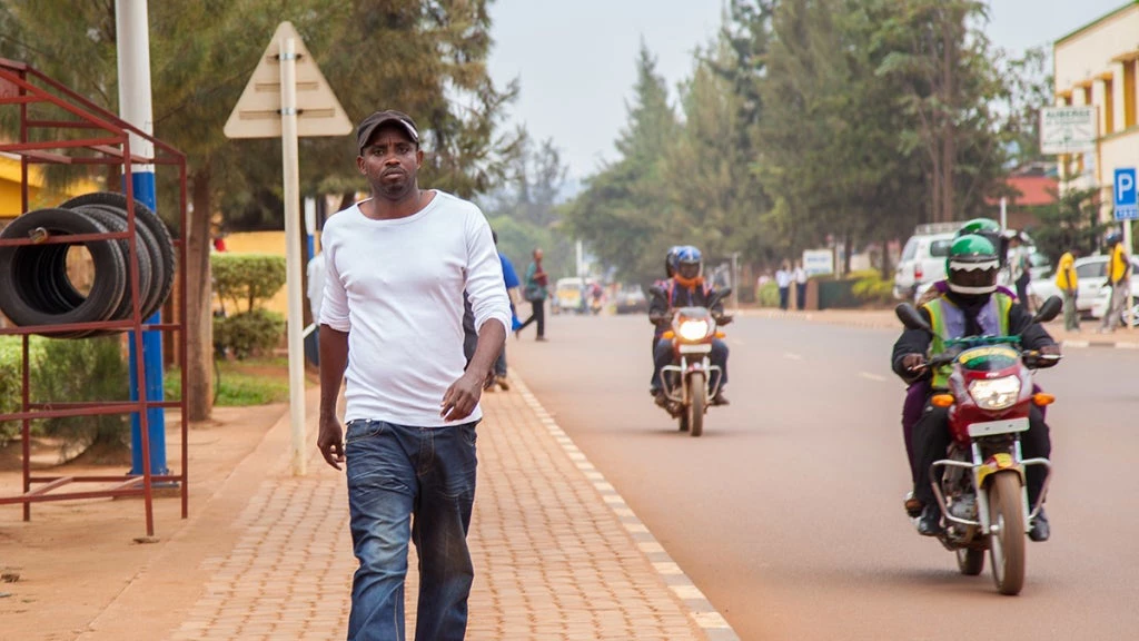 A man walks down a busy road in Kampala, Uganda. Photo: Sarah Farhat/World Bank