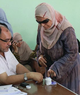 A woman putting her finger in the ink bottle as a proof that she already cast her vote in al-Mahalla, Egypt. 05-23-2013. Photo by Nehal El-Sherig.