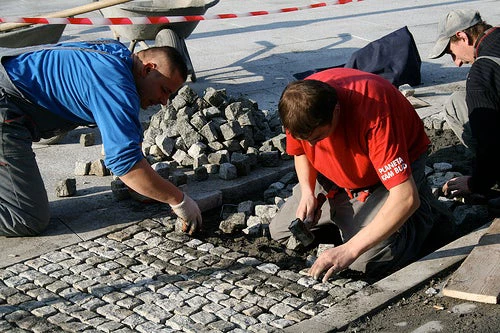 Laying cobblestones in Krakow. Photo credit: Flickr @Let Ideas Compete