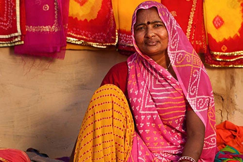 Woman selling colorful fabrics, India. Photo credit: iStock @hadynyah