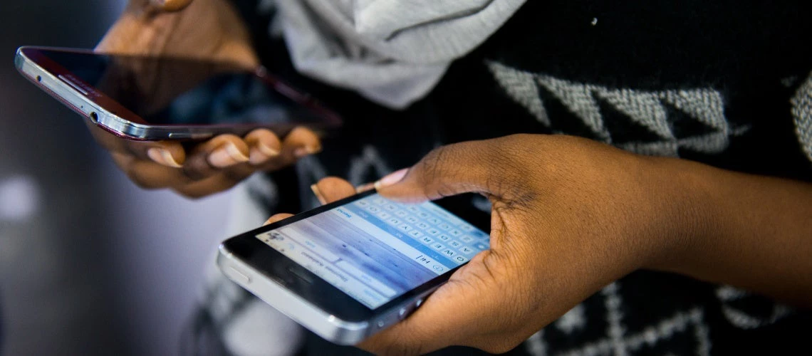 Person using two different smartphones