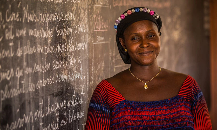 Photograph of a woman inside a classroom smiling