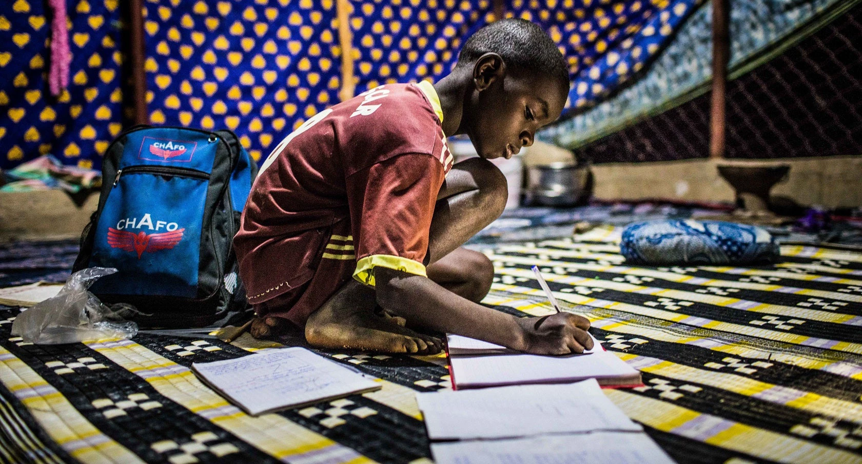 Sebani Gueye, 10 ans, fait ses devoirs à la maison dans un village du Sénégal. Sa famille vient d'avoir l'électricité et il n'a enfin plus besoin d'étudier à la lumière des bougies. Photo: © Vincent Tremeau/Banque mondiale