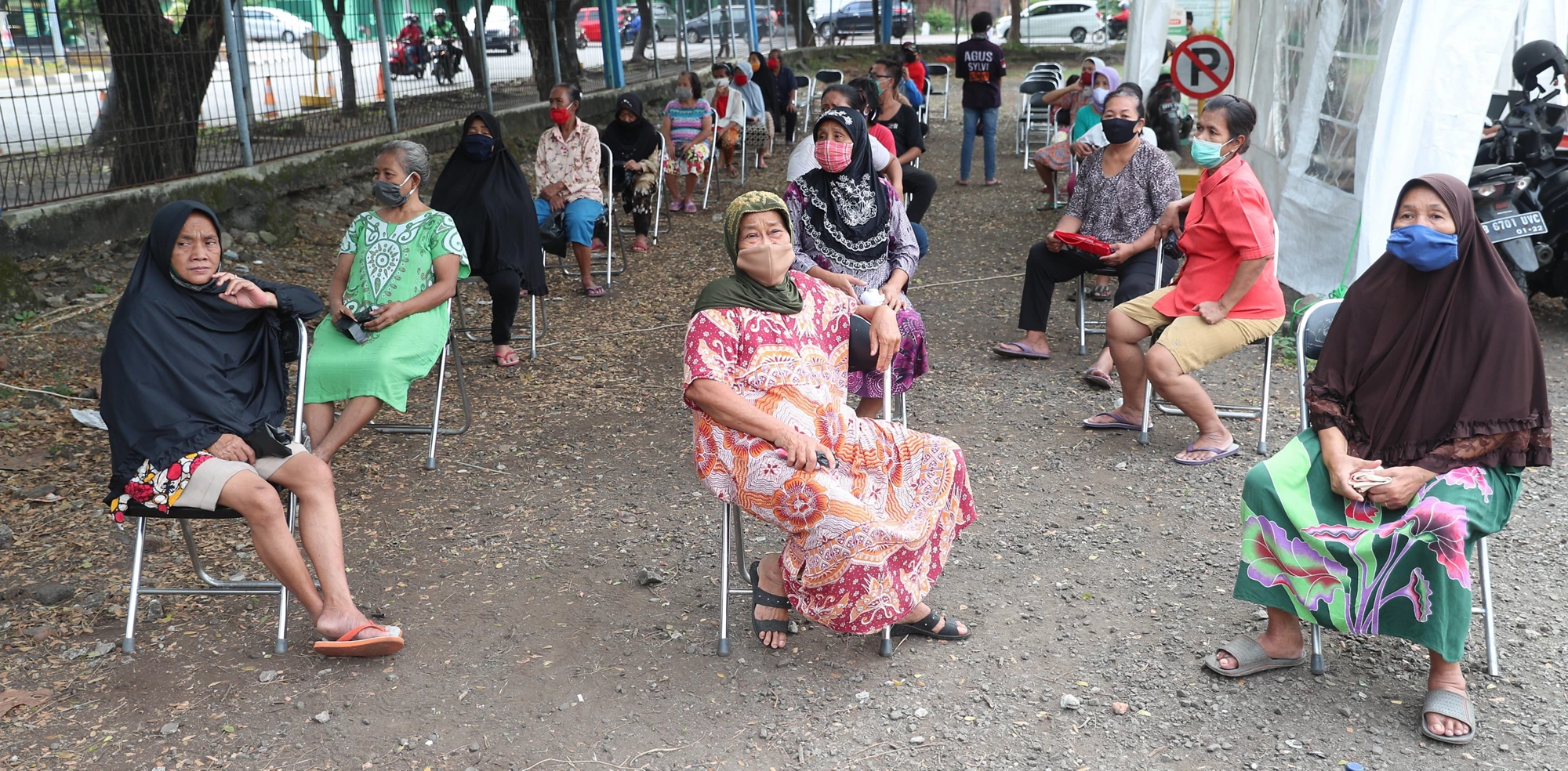 En Indonésie, des personnes pratiquent la distanciation physique lors de la réception de l?aide sociale. Photo :  Achmad/Banque mondiale