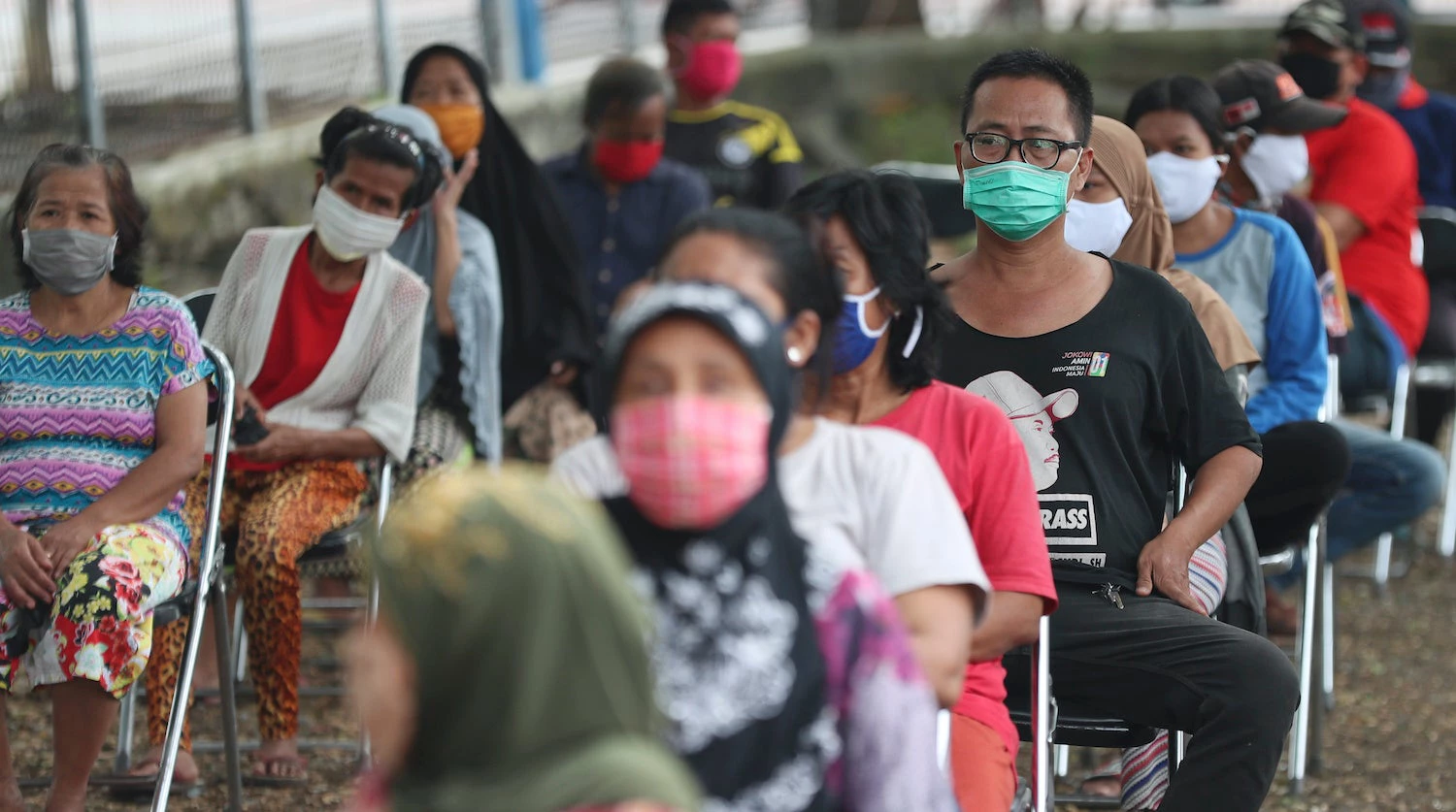 Un groupe de personnes pratiquent la distanciation sociale en attendant des dons de nourriture à Jakarta, en Indonésie. Photo : © Banque mondiale