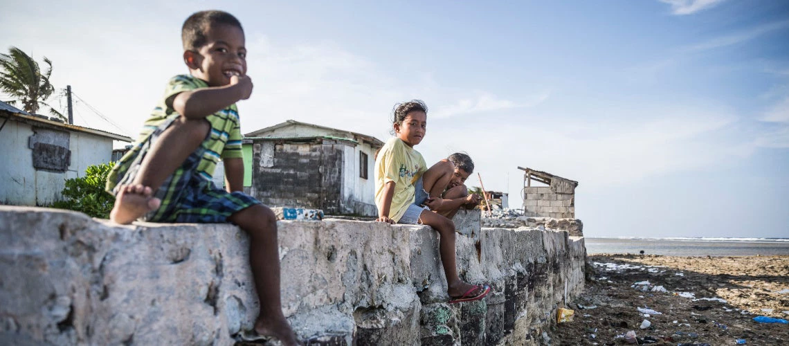 Marshall Islands ? Children sitting on a seawall near their family houses. Their home village of Jenrok in Majuro is slowly being destroyed by the rising seas. 