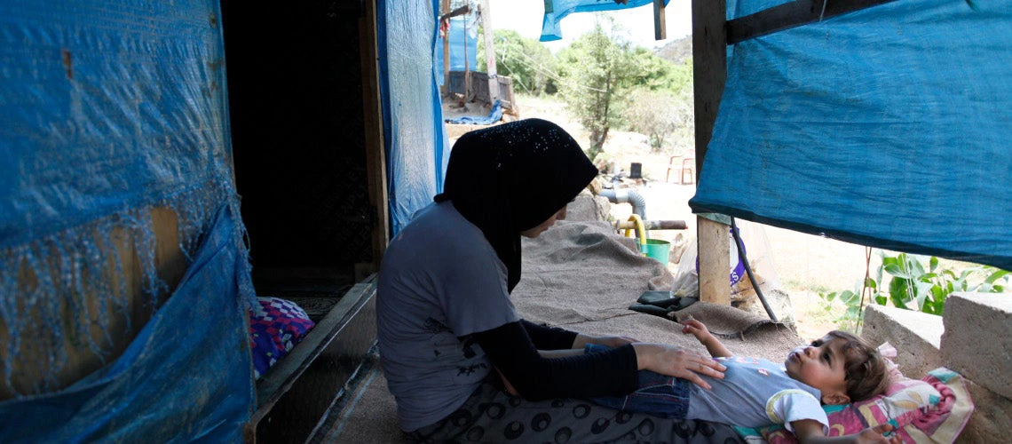 Fatatima plays with her son, Mouath in their makeshift home in the Ketermaya refugee camp. Photo © Dominic Chavez/World Bank