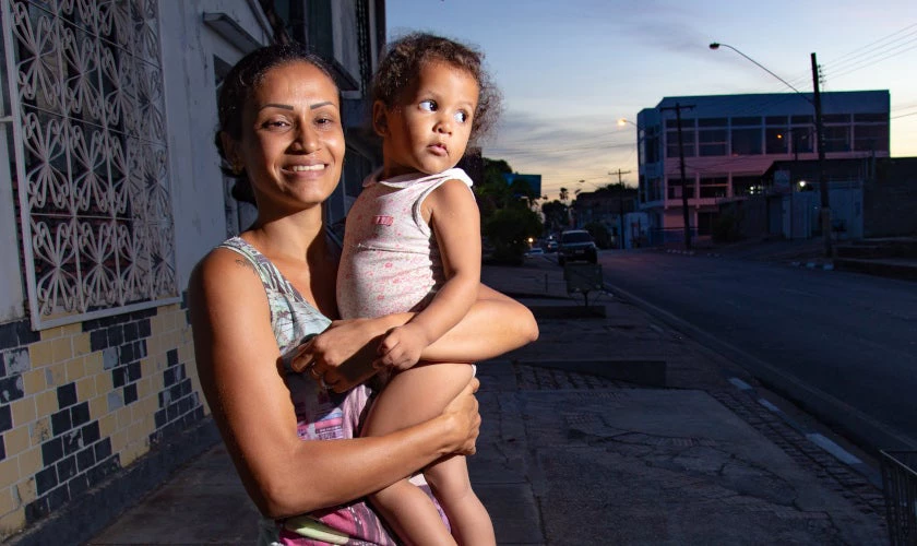 Venezuelan refugee holding her daughter.  Photo: Michael John Swan