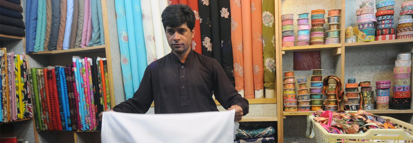 A worker at the cloth section of a cosmetics shop and general store