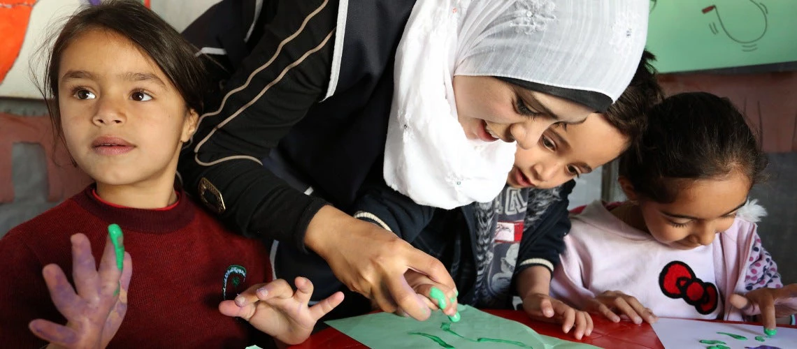 Syrian refugees learn to finger paint by their Lebanese teacher