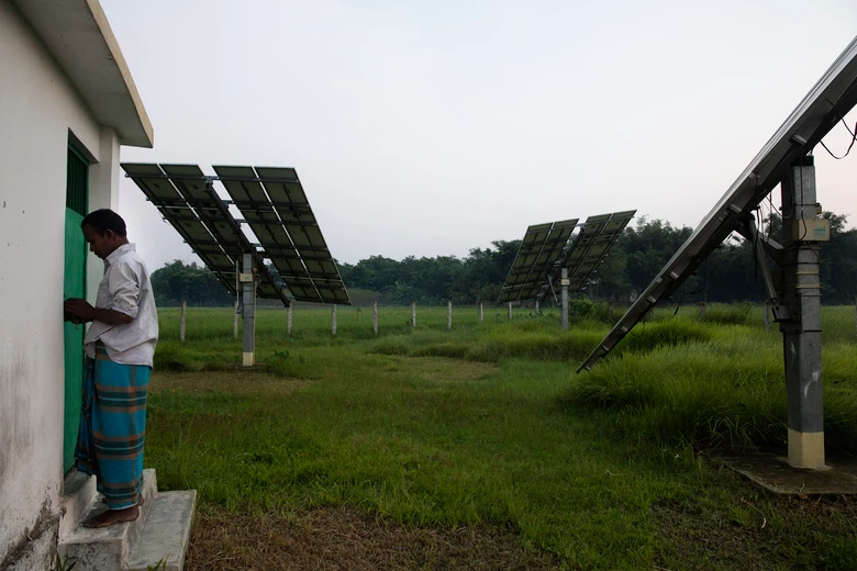 Un opérateur de pompe solaire travaille à proximité des panneaux solaires à Rohertek, au Bangladesh