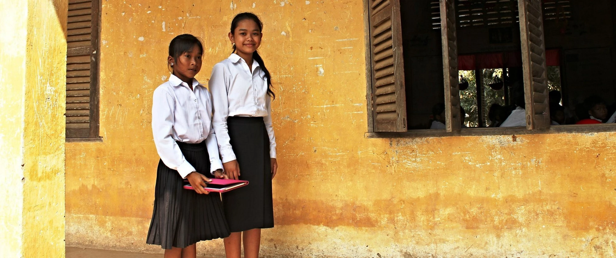 Las niñas están de pie fuera del aula. 