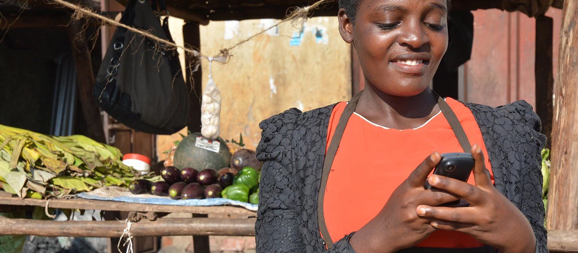 © Anna Koblanck / IFC. Sarah, a business owner, is using mobile banking services.