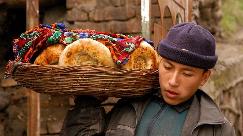 A boy carries bread about to be sold