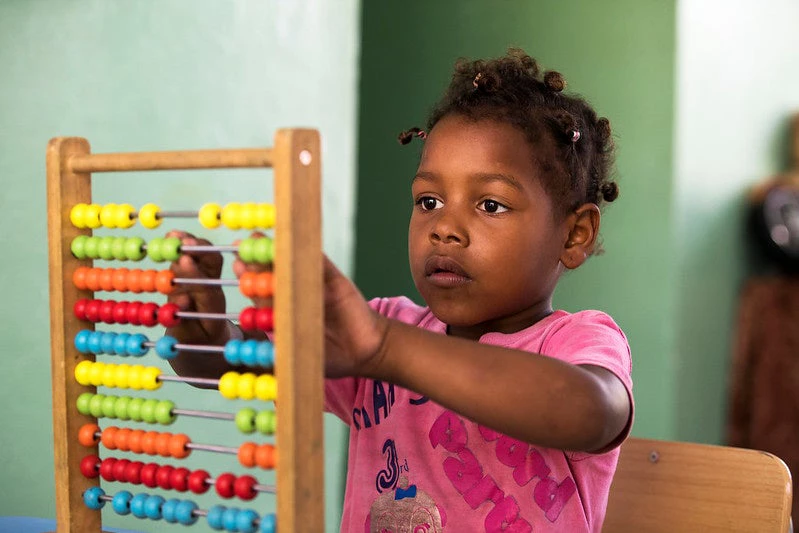    A girl plays with an abacus at the New Salome Ureña School in the Capotillo neighborhood in the city of Santo Domingo on June 25, 2021, in the Dominican Republic.  Photo: Orlando Barría