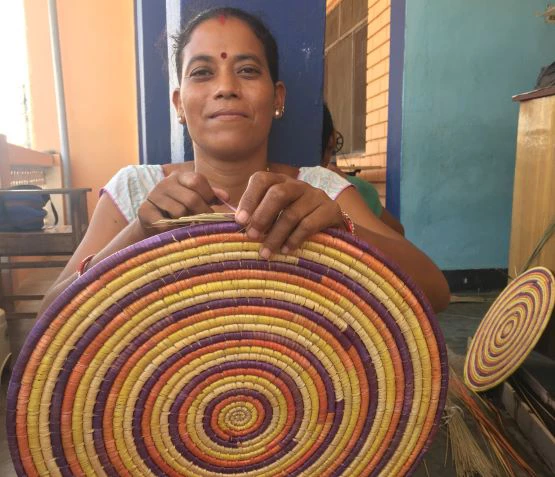 An indigenous Tharu woman from Nepal weaves a traditional basket, dhakia. Photo: Maya Rai