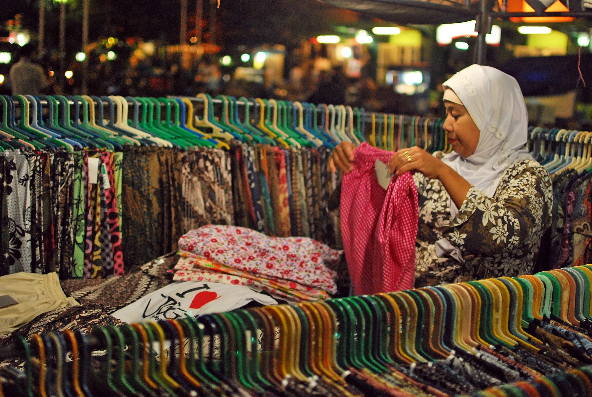 A woman buys clothes in a store in Indonesia.