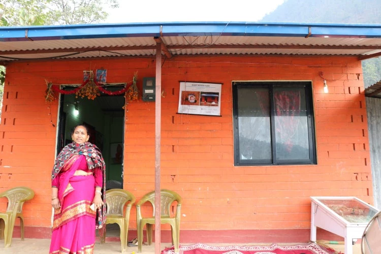 A woman in front of her newly-built house in Nuwakot, Nepal 