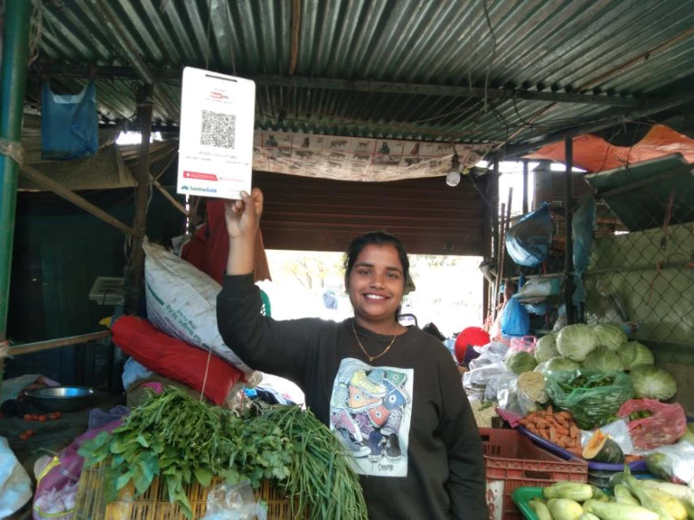 Nabina Yadav displays the card with a QR-code in her vegetable stall