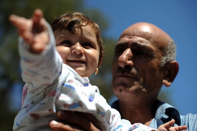 Un jeune enfant dans les bras de son grand-père