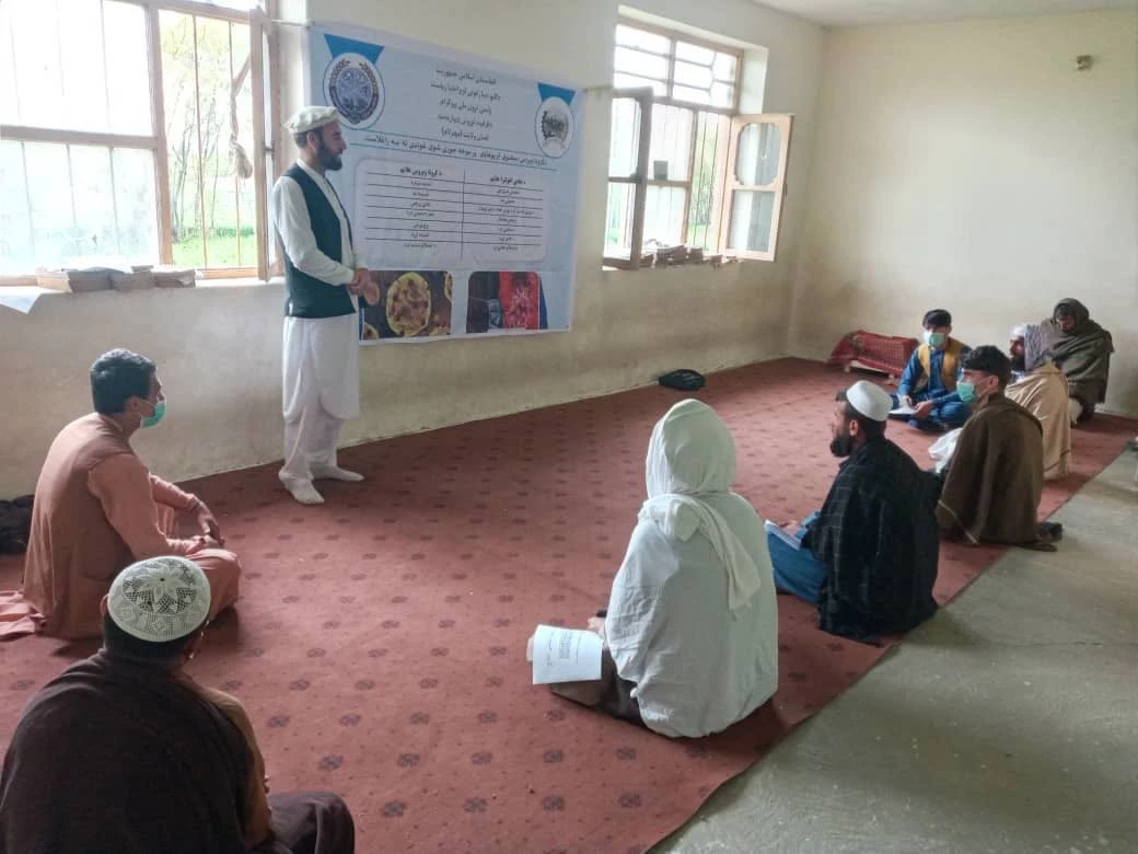 A World Bank project staff raising awareness among rural Afghans on COVID-19