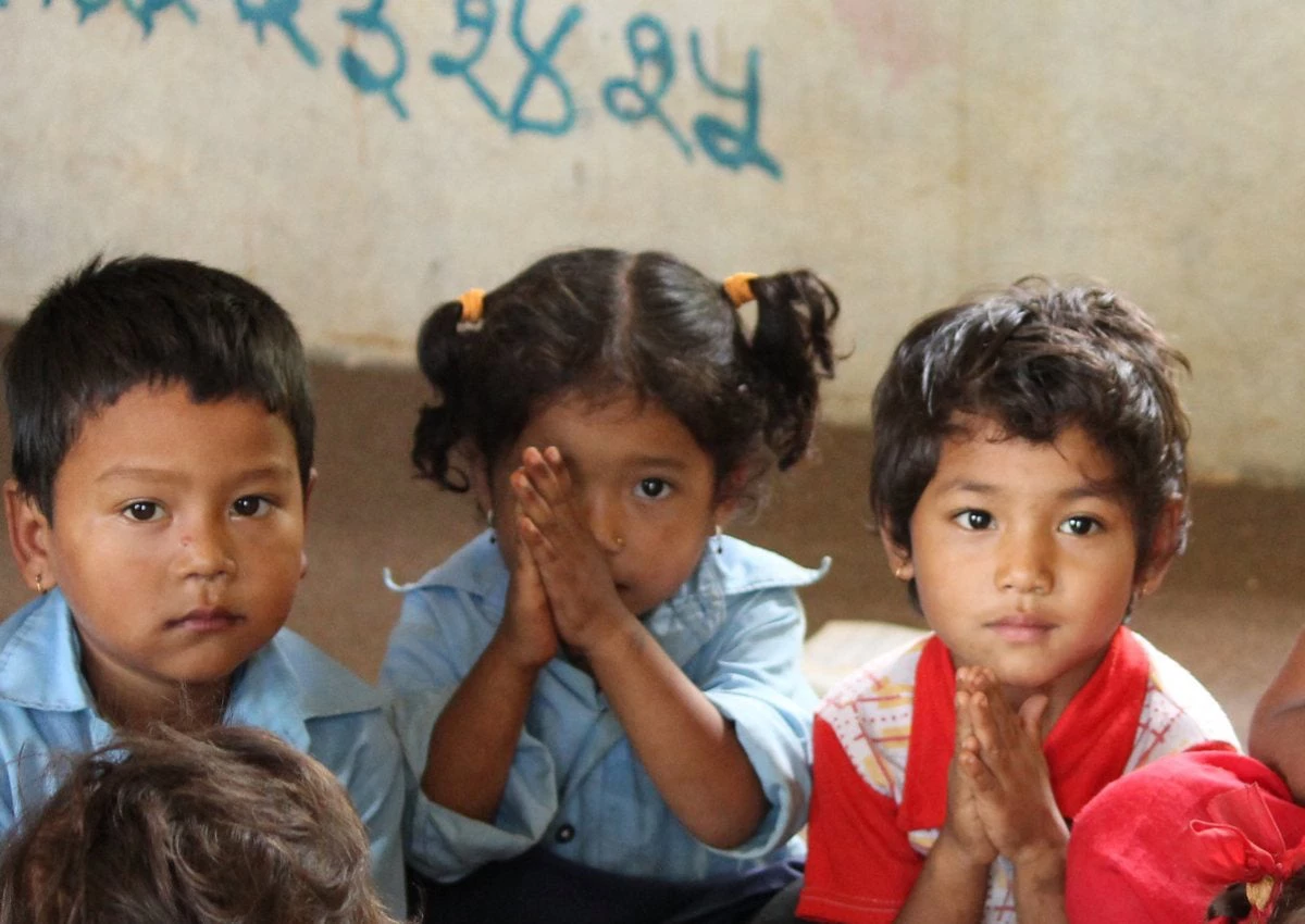 A class of 4 year olds and their teacher say namaste in rural Nepal. 